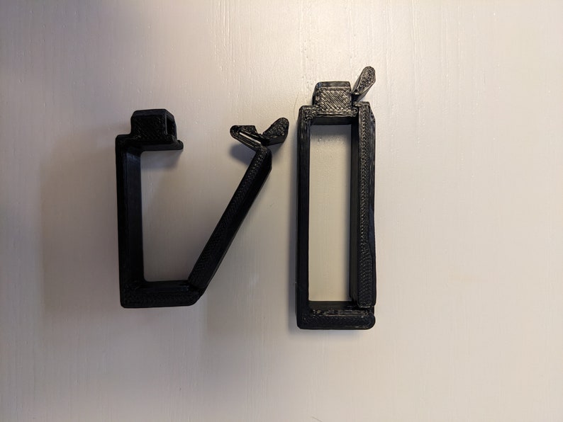 May include: Two black plastic cable clips, one with a hinged design and the other with a straight design.