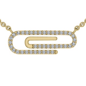May include: A gold-colored paperclip pendant necklace. The paperclip design is encrusted with small, clear gemstones. The necklace chain is also gold-colored and delicate. The pendant is centered on a white background.
