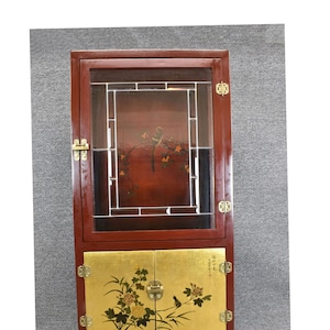 May include: A mahogany wood cabinet with glass doors and two lower doors. The glass doors have a decorative lattice design and the lower doors have gold leaf with painted floral and bird designs. The cabinet has brass hinges and hardware.