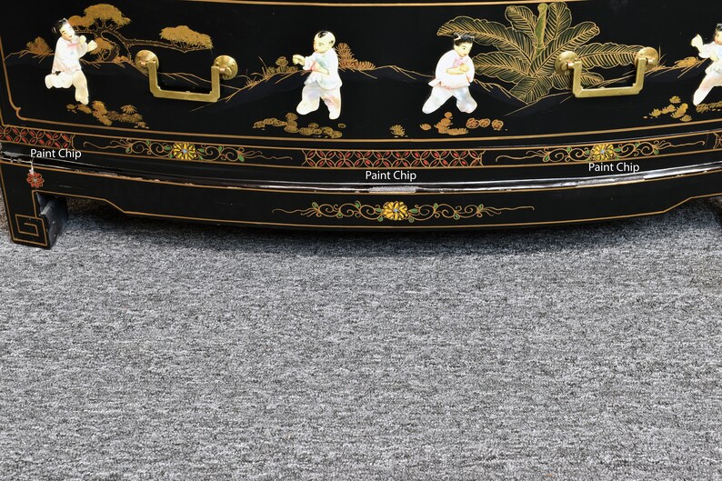 Pode incluir: Um arm&aacute;rio de madeira lacado de preto com detalhes dourados e pintados &agrave; m&atilde;o. O arm&aacute;rio apresenta uma frente curva e tr&ecirc;s gavetas com puxadores dourados. O arm&aacute;rio &eacute; decorado com um desenho floral e figuras em estilo chin&ecirc;s tradicional.