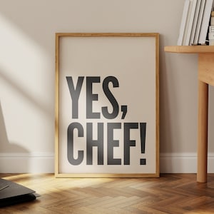 Könnte beinhalten: Ein gerahmter Druck mit weißem Hintergrund und schwarzem Text, der "YES, CHEF!" lautet. Der Rahmen ist aus Naturholz.