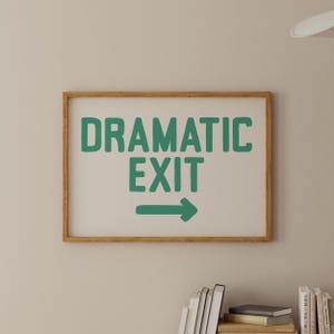 May include: A framed print with a white background and a green arrow pointing to the right. The text "DRAMATIC EXIT" is written in green letters.