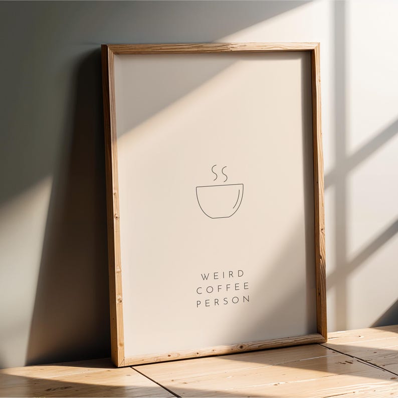 May include: A framed print with a minimalist line drawing of a steaming cup of coffee and the text "Weird Coffee Person".
