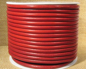 May include: A spool of red leather cord. The cord is wound tightly around a white plastic spool.