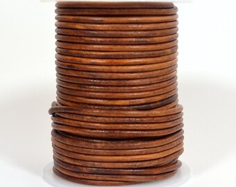 May include: A spool of brown leather cord, wound tightly in a coil. The cord is approximately 1/8 inch thick and has a natural, rustic look.