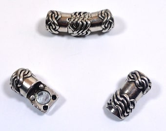 May include: Three silver metal magnetic clasps for a bracelet or necklace. The clasps are designed with a braided pattern.
