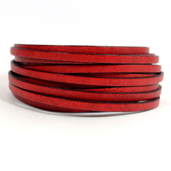 May include: A close-up of a red leather cord, rolled up and ready for crafting projects.