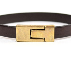 May include: A brown leather bracelet with a gold-toned metal clasp.
