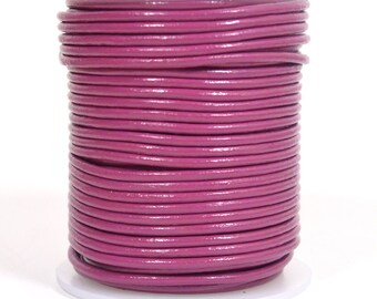 May include: A spool of deep pink leather cord. The cord is wound tightly around a white plastic spool.