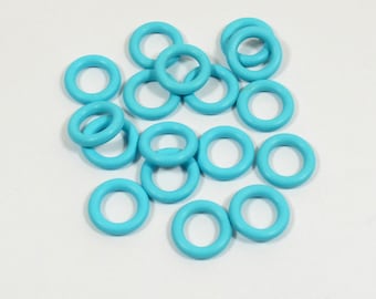 May include: A group of 18 turquoise colored plastic rings. The rings are all the same size and are arranged in a pile.