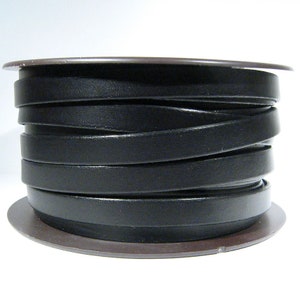 May include: A spool of black leather cord, wound tightly and ready for crafting projects.