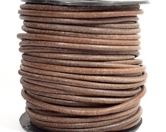 May include: A spool of brown leather cord, wound tightly in a coil. The cord is smooth and supple, with a natural, rustic look.