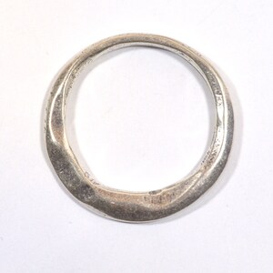 May include: A silver ring with a smooth, rounded, and slightly irregular shape.