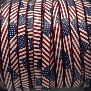 May include: A roll of red, white, and blue leather cord with a repeating pattern of American flags. The cord is approximately 1/2 inch wide.