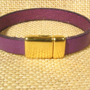May include: A purple leather bracelet with a gold magnetic clasp.
