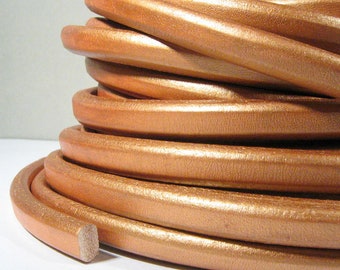May include: A coil of metallic gold leather cord. The cord is smooth and shiny, with a slight sheen.