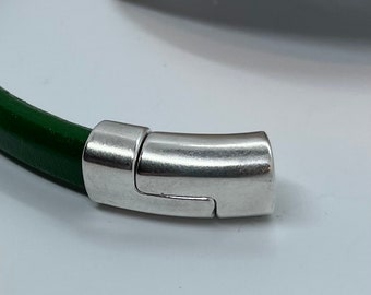 May include: A green leather bracelet with a silver magnetic clasp.