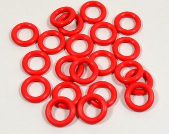 May include: A group of 20 bright red rubber O-rings. The rings are all the same size and are arranged in a random pattern.