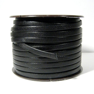 May include: A spool of black leather cord, wound tightly in a coil. The cord is smooth and has a slight sheen.