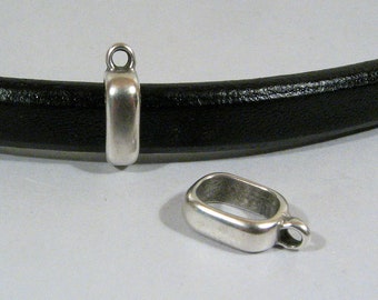 May include: Two silver metal clasps for leather bracelets. The clasps are rectangular with a small loop on one end. One clasp is shown on a black leather bracelet.