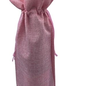 May include: Pink burlap wine bottle bag with a drawstring closure.