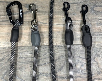 May include: Four different dog leashes with black and white rope and black metal clasps. The leashes have a black rubber handle with the text "Fury Leash" on one of the leashes.