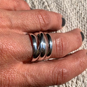 Pu&ograve; includere: Un anello d'argento con un design intrecciato. L'anello &egrave; composto da pi&ugrave; bande intrecciate.