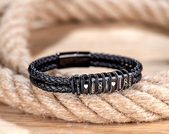 May include: Black leather bracelet with engraved metal beads. The beads include the names "Fernando", "Paula", "Forever", and the dates "12.14.2019" and "11.11.2021".