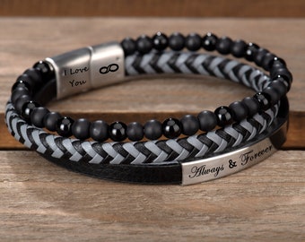 May include: A black leather bracelet with a grey braided leather band and black beads. The bracelet has two metal plates with the engraved text "I Love You" and "Always & Forever".