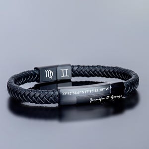 Può includere: Braccialetto in pelle nera con design intrecciato. Il braccialetto ha una placca metallica con i segni zodiacali Vergine e Gemelli, le coordinate "23°42'36.6"N17°15'43.38"W", e il testo "Jennifer & George".