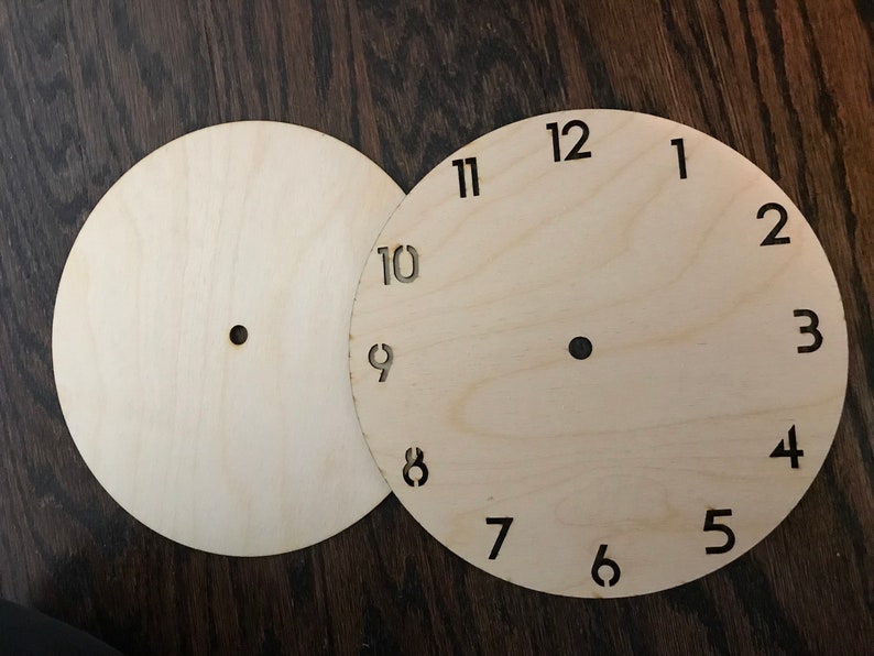 May include: Two unfinished wooden clock faces, one with numbers 1 through 12 and the other blank.