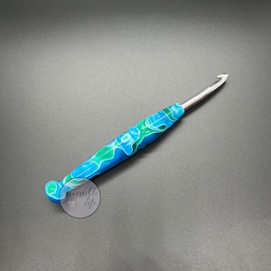 Ergonomischer blauer und blaugrüner handgedrechselter gehäkelter Griff mit einem verjüngten silbernen Häkelnadel 6.0 mm