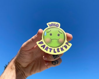 May include: A yellow sticker with a green cartoon face that says "WHO FARTLEK'D?" The face is sweating and has a worried expression.
