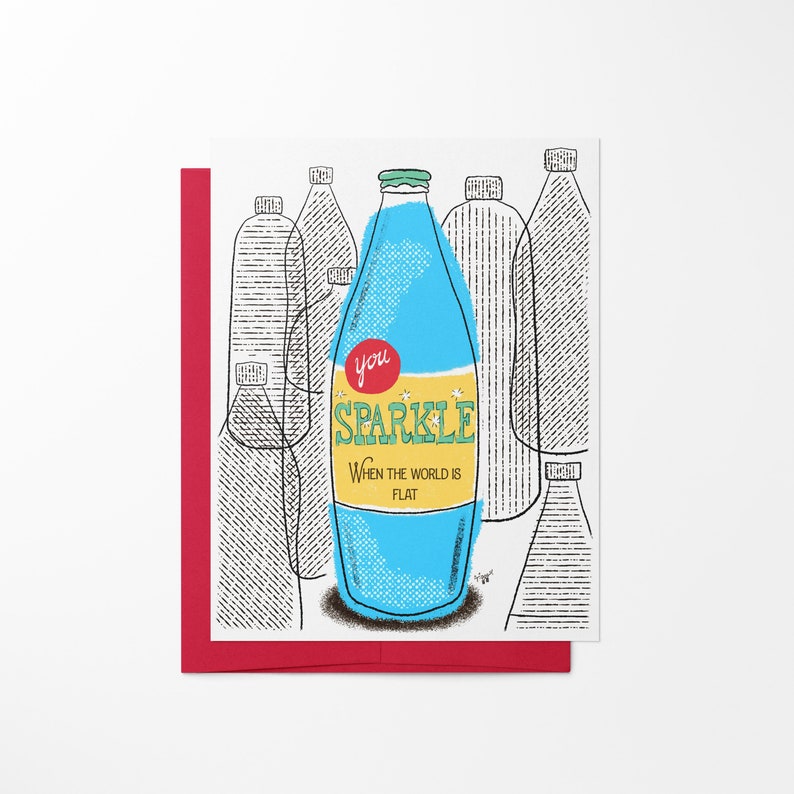 Bright blue bottle of sparkling water with text that reads, "You Sparkle When The World Is Flat". Red envelope.