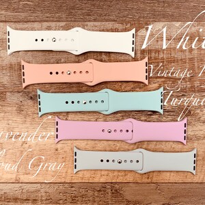 May include: Five different colored Apple Watch bands. The bands are in the following colors: white, vintage rose, turquoise, lavender, and cloud gray.