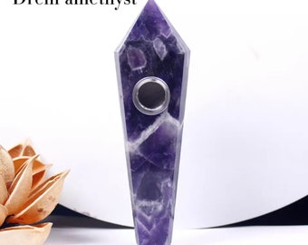 May include: A purple amethyst crystal pipe with a metal bowl. The pipe is shaped like a long, pointed crystal.