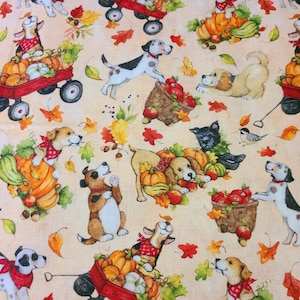 May include: A repeating pattern fabric featuring playful dogs, pumpkins, gourds, and apples. The dogs are depicted with bandanas and are pulling red wagons. Autumn leaves and a light peach background complete the fall theme.