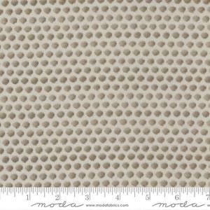May include: A beige fabric with a repeating pattern of small, brown, textured dots.