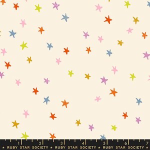 May include: A white fabric with a repeating pattern of colorful stars. The stars are in various shades of pink, orange, yellow, blue, and purple. The fabric has a subtle texture and a slightly off-white background.