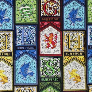 May include: A fabric pattern featuring stained-glass style panels with the crests of Hogwarts houses. Each panel has a different house crest, including a lion for Gryffindor, a snake for Slytherin, a raven for Ravenclaw, and a badger for Hufflepuff.