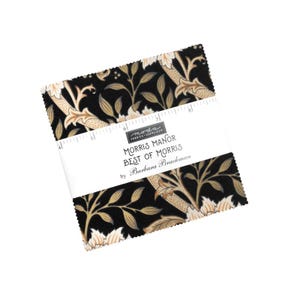 May include: A stack of fabric squares with a floral pattern in black, beige, and cream. The fabric is wrapped with a white band that reads "MORRIS MANOR BEST OF MORRIS by Barbara Brackman."