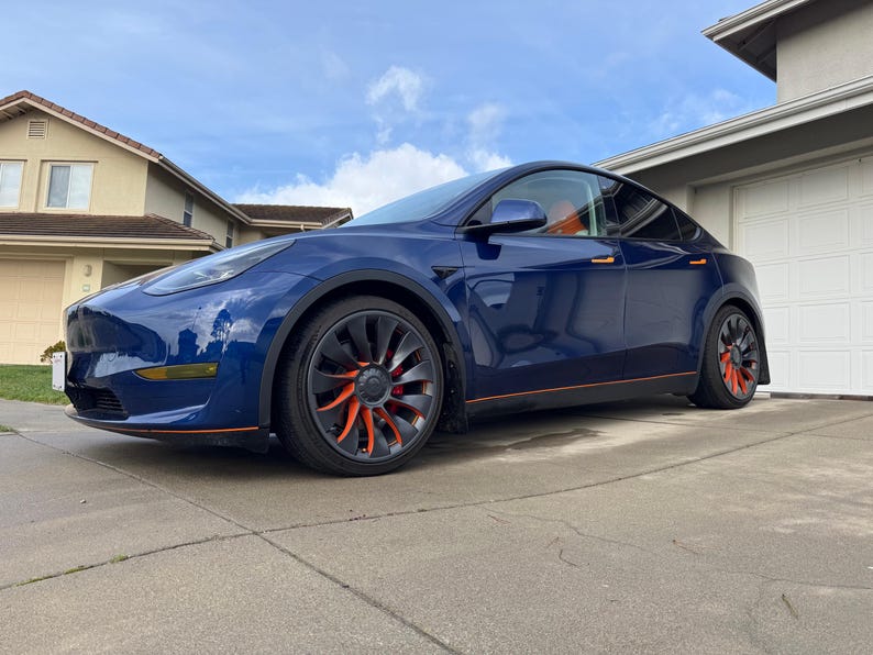 Blue Model Y with orange Turbine Tats on its wheels
