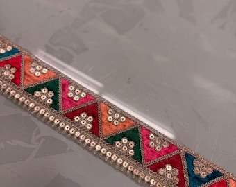 Cinturón de moda: Accesorio de mano con cinta de encaje y cuentas. Opciones de color y diseño disponibles.