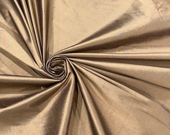 May include: A close-up of a smooth, silky fabric in a rich brown color. The fabric is draped and folded, showcasing its luxurious texture.