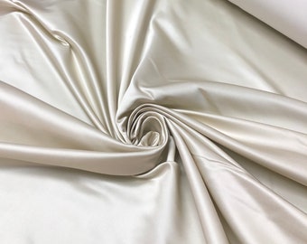 Beautiful champagne egg shell color silk rayon Satin 48” wide.  Best used for bridal dresses sold by the yard