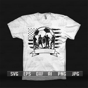 K&ouml;nnte beinhalten: Wei&szlig;es T-Shirt mit einem Fu&szlig;ball-Design, das die amerikanische Flagge und vier Spielersilhouetten enth&auml;lt. Am unteren Rand befindet sich ein Banner. Das T-Shirt hat kurze &Auml;rmel und einen Rundhalsausschnitt. Das Design ist in Schwarz.