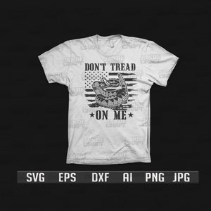 May include: A white t-shirt with a black and white graphic design. The graphic features a rattlesnake coiled around an American flag with the text "Don't Tread On Me".