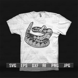 May include: A white t-shirt featuring a black and white illustration of a coiled rattlesnake on the front. The text "SVG EPS DXF AI PNG JPG" is printed below the image.