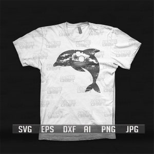 以下が含まれることがあります： 白いTシャツに、水から飛び出すイルカの黒いシルエットが描かれています。背景にはヤシの木と太陽があります。シャツには「JADE CRAFT」という文字が繰り返しパターンで書かれています。