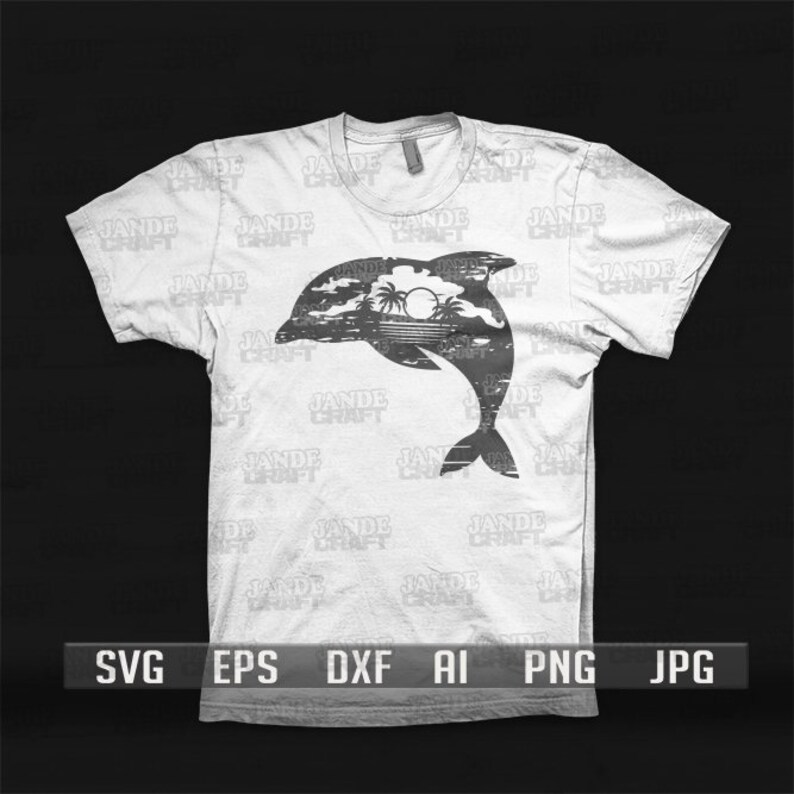以下が含まれることがあります： 白いTシャツに、水から飛び出すイルカの黒いシルエットが描かれています。背景にはヤシの木と太陽があります。シャツには「JADE CRAFT」という文字が繰り返しパターンで書かれています。